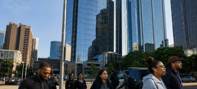 A surveillance camera mounted on an urban Seattle street corner, corporate office buildings and a police cruiser visible in the background, documentary photography style.