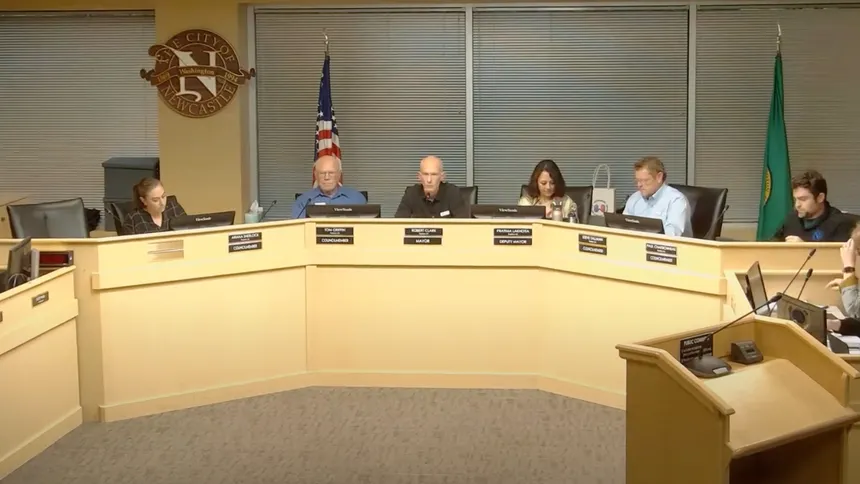 Newcastle City Council members are seated at the Newcastle City Council meeting, with Mayor Robert Clark at the center.